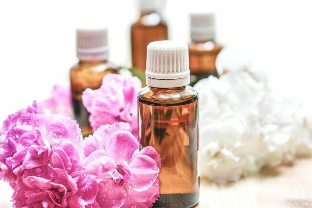 Pink and white flowers with brown bottles of essential oils