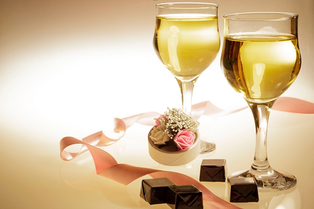 Two wine glasses with flowers and chocolates